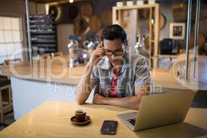 Man using laptop in restaurant