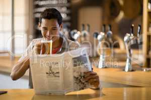 Man having beer while reading newspaper in a restaurant