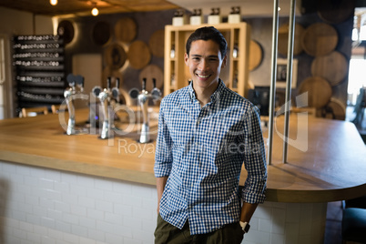 Smiling man standing at counter in restaurant