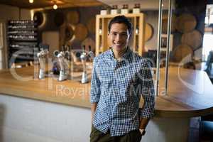 Smiling man standing at counter in restaurant