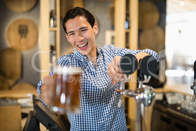 Bar tender offering glass of beer to customer