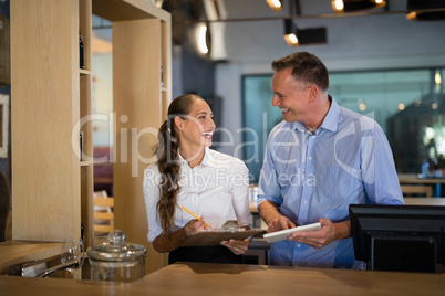 Smiling manager and bartender interacting with each other