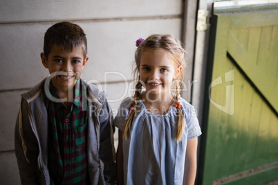 Siblings standing together in barn