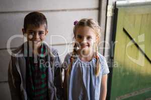 Siblings standing together in barn