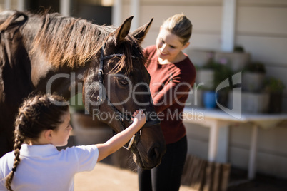 Mother and daughter touching the horse