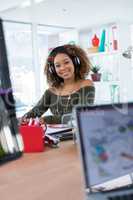 Female executive in headphones working at desk