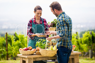 Woman selling organic vegetables to man