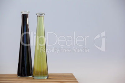 Black and green olive oil in bottle on table