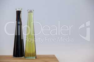 Black and green olive oil in bottle on table