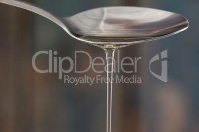 Spoon pouring olive oil