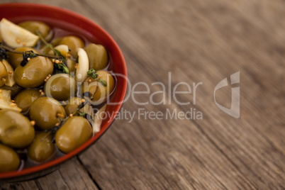 Cropped image of olives with garlic and oil in bowl