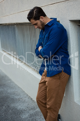 Thoughtful man with arms crossed looking down