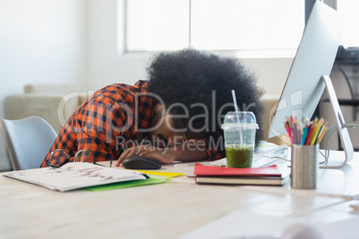 Man with curly hair relaxing at desk in office