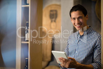 Bar tender holding digital tablet at counter