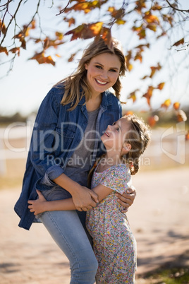 Happy mother and daughter having fun in park