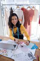 Female designer working on pieces of clothes in office