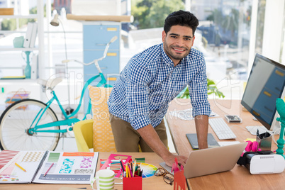 Graphic designer working on laptop at desk