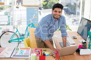 Graphic designer working on laptop at desk