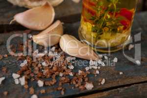 Spices and garlic bulbs by herb with oil in container