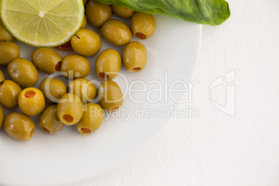 Overhead view of olives with lemon in plate