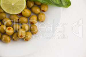 Overhead view of olives with lemon in plate