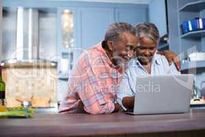 Smiling couple using laptop computer