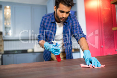 Young man cleaning table