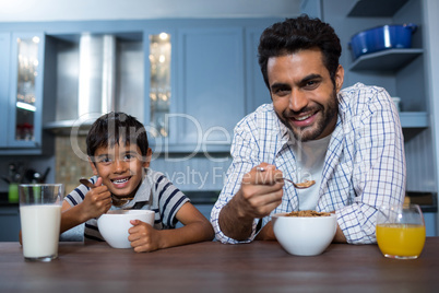 Portrait of father and son having breakfast
