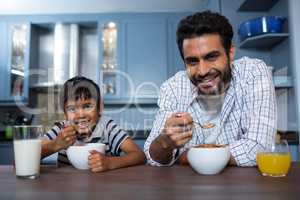 Portrait of father and son having breakfast