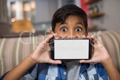 Portrait of boy showing smartphone