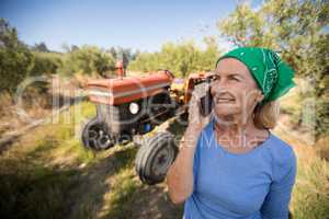 Happy woman talking on mobile phone in olive farm