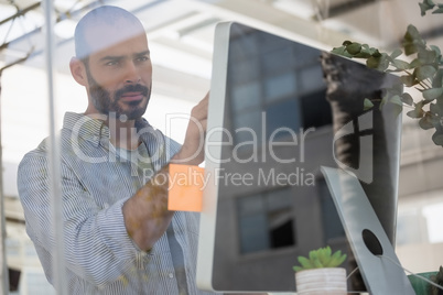 Designer using computer in studio seen through glass