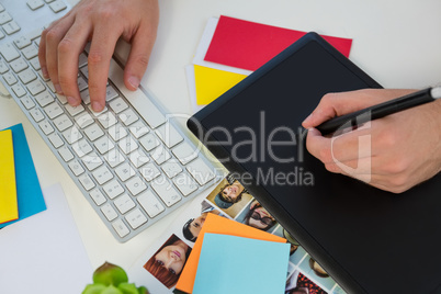 Cropped hand of designer writing on graphics tablet