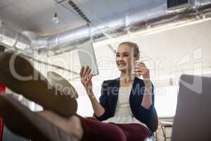 Businesswoman using digital tablet while relaxing