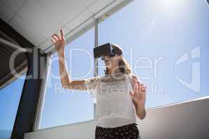 Low angle view of businesswoman using virtual reality simulator by window
