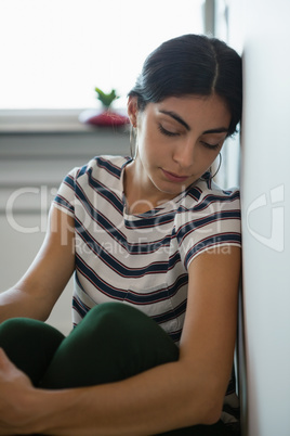 Tired woman sleeping by wall at office