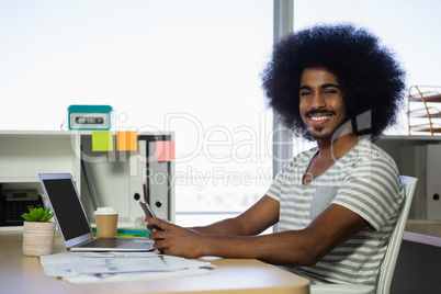 Portrait of man using phone in office