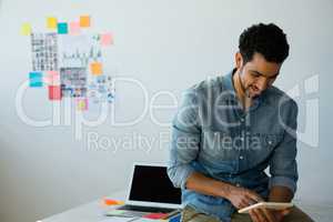 Businessman using digital tablet while sitting on desk