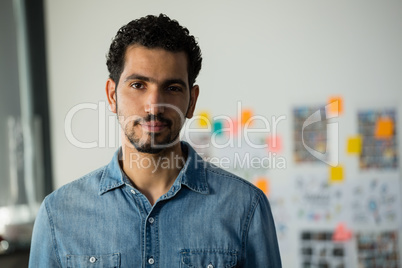 Portrait of young man standing in office
