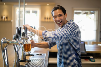 Bar tender filling beer from beer pump