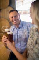 Couple interacting with each other while having beer in bar