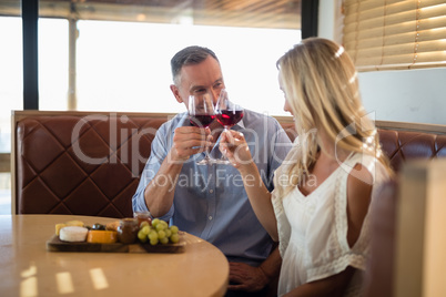 Happy couple toasting wine glass while having meal