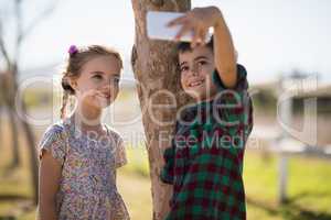 Happy siblings taking selfie on mobile phone