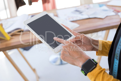 Fashion designer using digital tablet in office