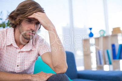 Depressed male executive sitting on sofa