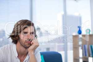 Depressed male executive sitting on sofa