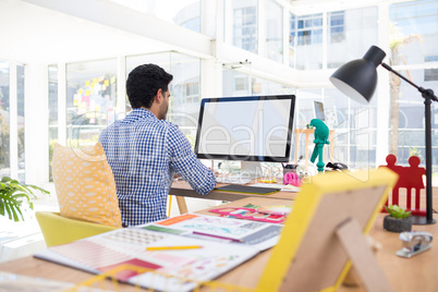 Graphic designer working on computer at desk