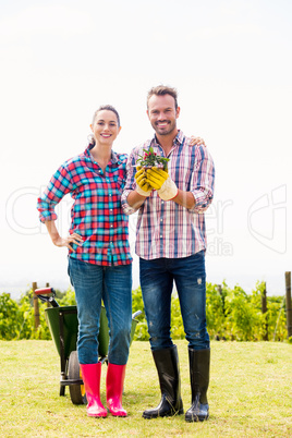 Portrait of man with woman holding potted plant