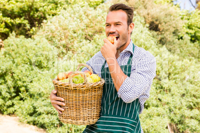 Young man with basket eating apple