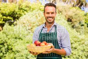 Portrait of smiling handsome man holding apple basket